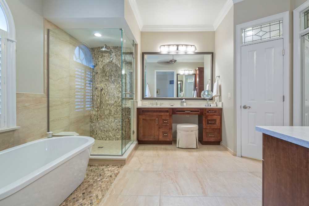 Contemporary bathroom featuring wooden cabinets and a stylish glass enclosure, crafted by Nativi Construction in Ventura County.